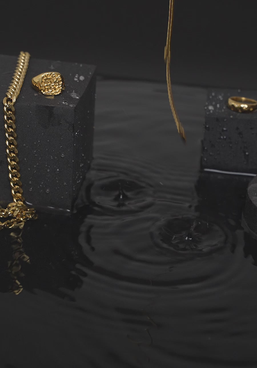 Vandfaste guldsmykker bliver overhældt med vand for at vise holdbarhed.